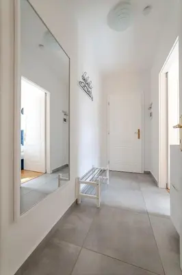 a large mirror in a white room with a hallway at De Luxe Suite with balcony in Angelo Residence by Rentez in Prague
