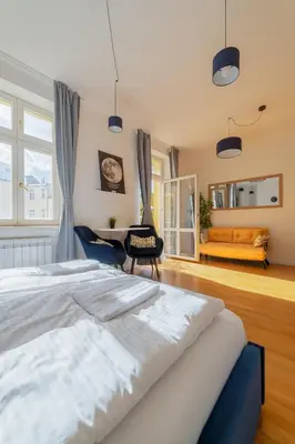 a large bedroom with a large bed and a chair at De Luxe Suite with balcony in Angelo Residence by Rentez in Prague