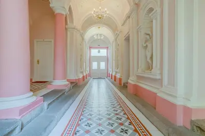 an empty hallway with pink columns and a door at De Luxe Suite with balcony in Angelo Residence by Rentez in Prague