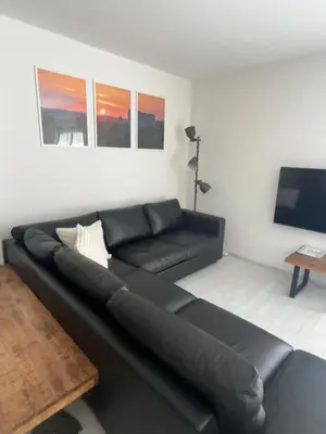 a black couch in a living room with a tv at Holiday Home Prague Šeberov in Prague