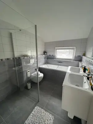a bathroom with a tub and a toilet and a sink at Holiday Home Prague Šeberov in Prague