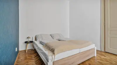 a bed in a white room with at Stylish Apartment near Wenceslas Square in Prague