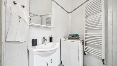 a white bathroom with a sink and a mirror at Stylish Apartment near Wenceslas Square in Prague