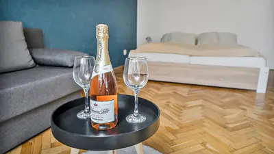 a bottle of champagne and two wine glasses on a table at Stylish Apartment near Wenceslas Square in Prague