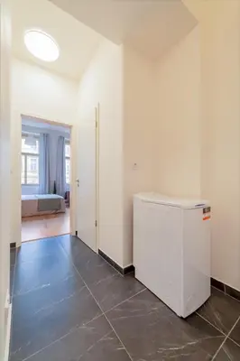an empty room with a refrigerator and a bedroom at City Center Deer Suite in Prague