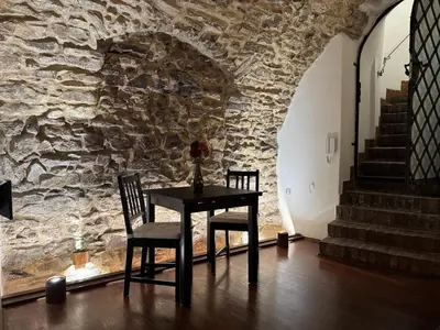 a table and two chairs in front of a stone wall at Historic Arch Apartment - Karlova Street in Prague