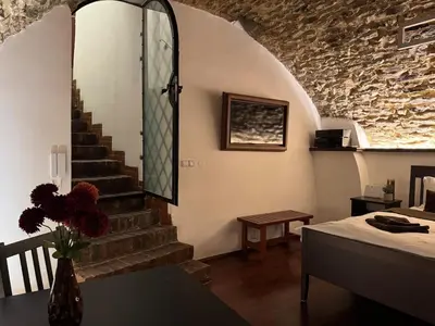 a living room with a staircase and a table at Historic Arch Apartment - Karlova Street in Prague