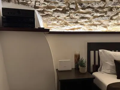 a bedroom with a bed and a stone wall at Historic Arch Apartment - Karlova Street in Prague
