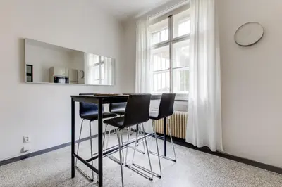 a kitchen with a table and two chairs and a clock at Large Garden Villa Suite Business-Leisure-Sports in Prague