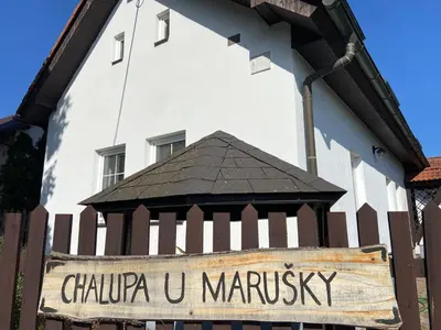a sign on a fence in front of a building at Chalupa u Marušky