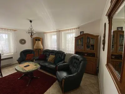 a living room with a black leather couch and a table at Chalupa u Marušky