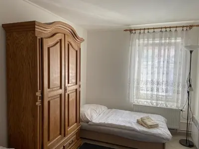 a bedroom with a large wooden cabinet next to a window at Chalupa u Marušky