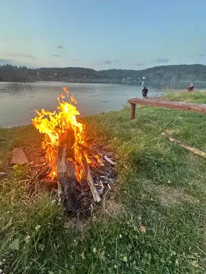a fire in the grass next to a body of water at Chatka Nová Živohošť in Křečovice