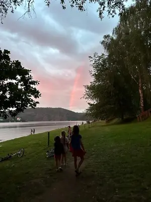 a group of people walking down a path with a rainbow in the sky at Chatka Nová Živohošť in Křečovice