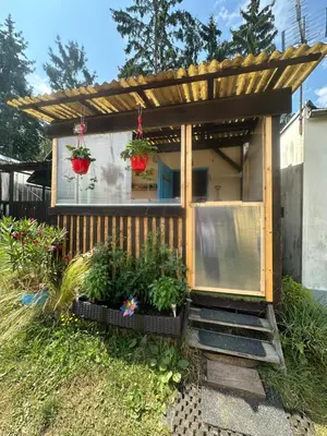 a tiny house with a pergola and some plants at Chatka Nová Živohošť in Křečovice