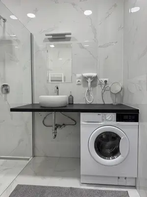 a bathroom with a washing machine and a sink at Luxury Modern Apartment with View in Prague