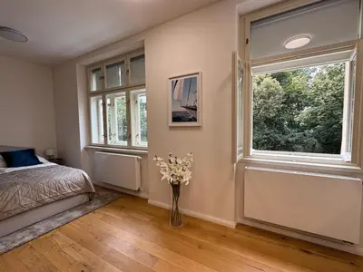 a bedroom with a bed and a vase with flowers in it at Luxury Modern Apartment with View in Prague
