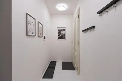 a hallway with white walls and a black and white rug at Luxury Modern Apartment with View in Prague