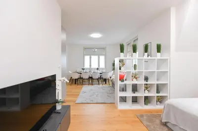 a white living room with a dining room at Luxury Modern Apartment with View in Prague