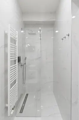 a white bathroom with a shower with a glass door at Luxury Modern Apartment with View in Prague