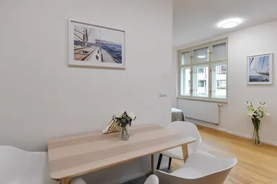 a dining room with a wooden table and white chairs at Luxury Modern Apartment with View in Prague