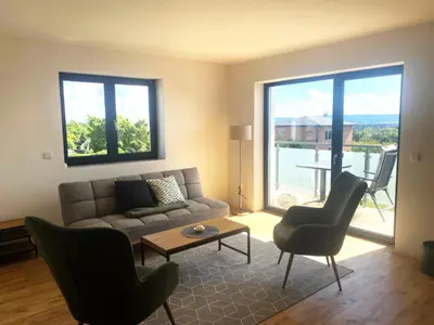 a living room with a couch and a table and chairs at Apartmány MB JARO Mladá Boleslav in Bradlec