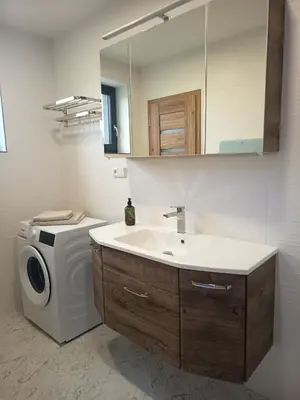 a bathroom with a sink and a washing machine at Apartmány MB JARO Mladá Boleslav in Bradlec