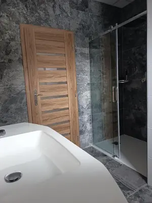 a bathroom with a shower and a white bath tub at Apartmány MB JARO Mladá Boleslav in Bradlec
