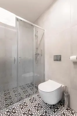 a white bathroom with a shower and a toilet at Luxury Oomph Apartments in Prague