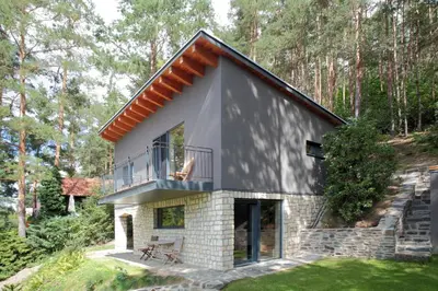 a house with a balcony on the side of it at Chata Nola Slapy in Křečovice