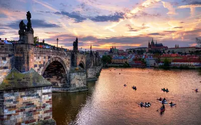 a group of people in boats on a river near a bridge at Red Rose Residence in Prague