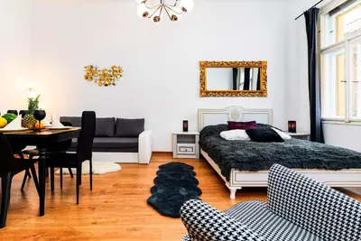 a bedroom with a bed and a table and a couch at Red Rose Residence in Prague