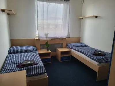 two beds in a small room with a window at Sporthotel Vestec in Vestec