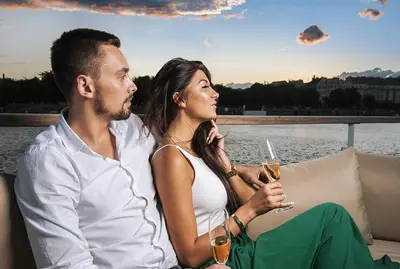 a man and a woman sitting on a couch with drinks at VIPliving Houseboat in Prague