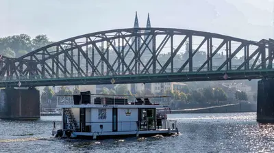 a boat in the water under a bridge at VIPliving Houseboat in Prague