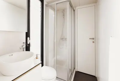a white bathroom with a sink and a shower at VIPliving Houseboat in Prague