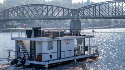 a ferry boat in the water under a bridge at VIPliving Houseboat in Prague