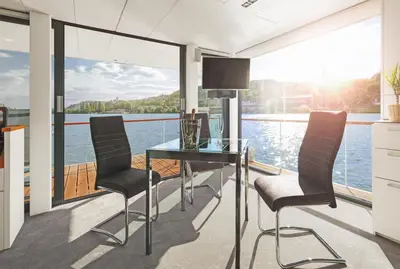 a dining room with a view of the water at VIPliving Houseboat in Prague