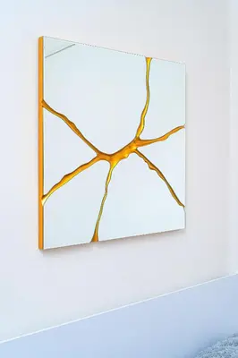 a mirror with a wooden frame hanging on a white wall at Victory Belle Maison in Prague