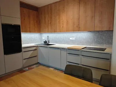 a kitchen with a wooden table and blue chairs at Kolbenova Comfort Stay in Prague
