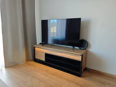 a flat screen tv sitting on top of a wooden entertainment center at Kolbenova Comfort Stay in Prague