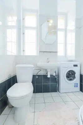 a bathroom with a toilet and a sink and a washing machine at Prague central 3&kk apartment Andel in Prague