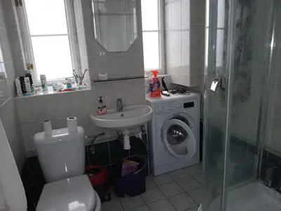 a bathroom with a toilet and a sink and a washing machine at Prague central 3&kk apartment Andel in Prague