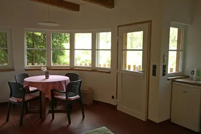 a dining room with a table and chairs and windows at Malběnka - chata na skále pod hradem Kokořín in Kokořín