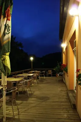 a deck with tables and chairs at night at Malběnka - chata na skále pod hradem Kokořín in Kokořín