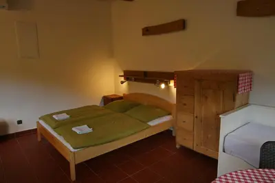 a bedroom with two beds and a wooden cabinet at Malběnka - chata na skále pod hradem Kokořín in Kokořín