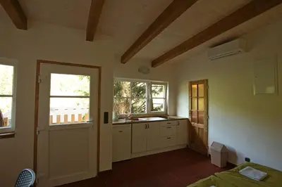 a room with a kitchen with a sink and a door at Malběnka - chata na skále pod hradem Kokořín in Kokořín