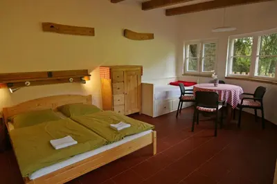 a bedroom with a bed and a table and chairs at Malběnka - chata na skále pod hradem Kokořín in Kokořín