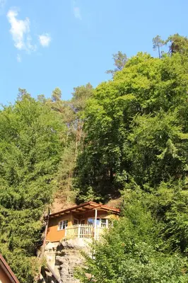 a house on the side of a hill with trees at Malběnka - chata na skále pod hradem Kokořín in Kokořín