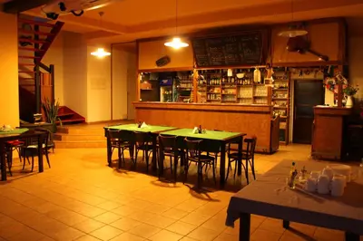 a restaurant with tables and chairs and a bar at Malběnka - chata na skále pod hradem Kokořín in Kokořín